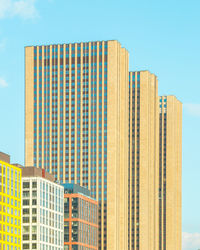 Low angle view of modern buildings against blue sky