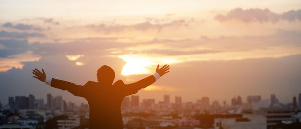 Silhouette hand raised fist business man with sun lighting in morning. 