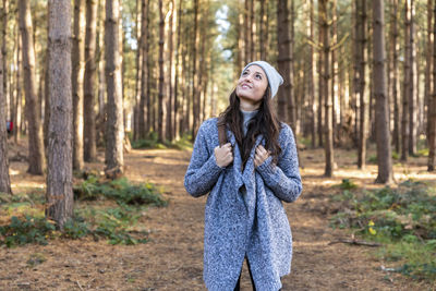 Smiling young woman in forest during autumn