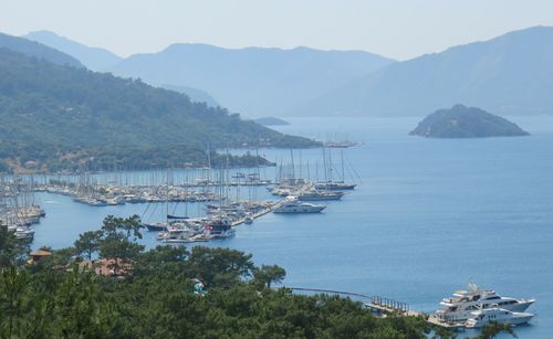 High angle view of sailboats moored in sea against sky