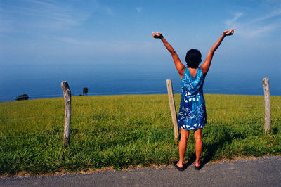 Full length rear view of man walking on grassland