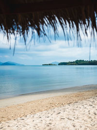 Scenic view of peaceful tropical island beach with thatched umbrella. koh mak island, trat, thailand