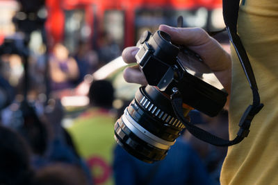 Midsection of man holding camera