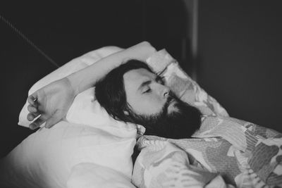 Bearded man lying on bed at home