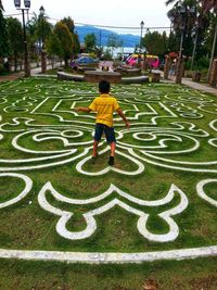 Rear view of boy playing in park