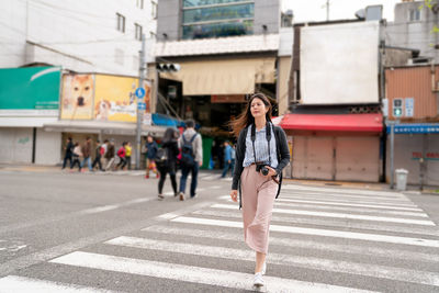 Full length portrait of woman standing on road