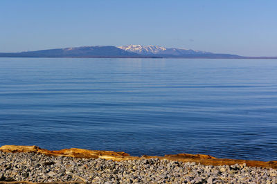 Scenic view of lake against clear blue sky