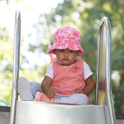 Cute baby girl sitting on slide