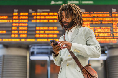 Businessman using smart phone at central station