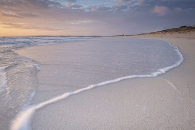 Scenic view of beach against sky during sunset