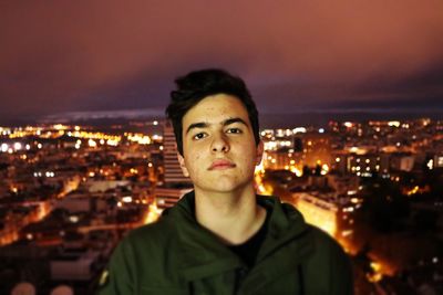 Portrait of man in city against sky at night