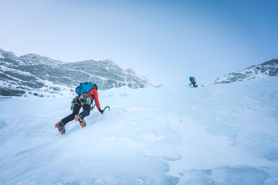 People skiing on snowcapped mountain against sky