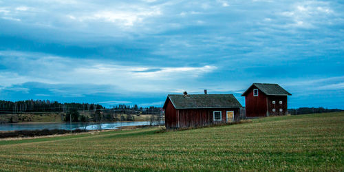 House on field against cloudy sky