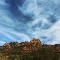 Rock formation against cloudy sky