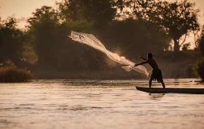 Man surfing on river against sky