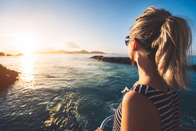 Side view of woman looking at sea against sky