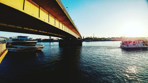 Bridge over river in city against clear sky