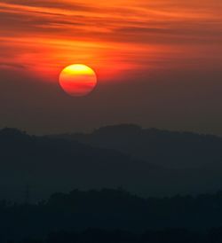 Scenic view of silhouette mountains against romantic sky at sunset