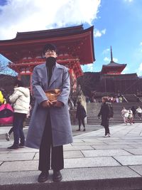 People standing outside temple against sky