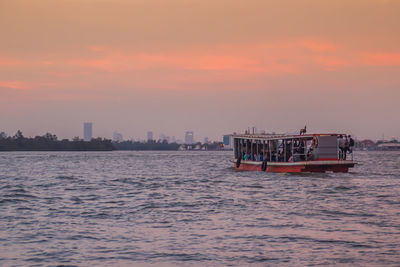 Ship sailing in sea against sky during sunset