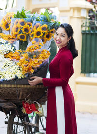Portrait of woman holding flower bouquet at market