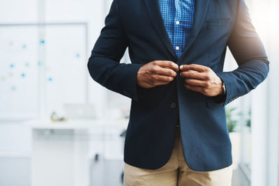 Midsection of businessman standing in office