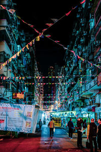 People walking on illuminated street at night