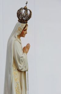 Virgin mary statue against white wall