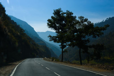 Road amidst trees against sky