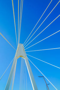 Low angle view of suspension bridge against sky