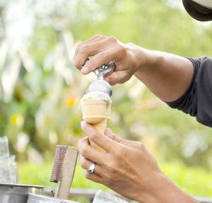 Cropped hands of vendor scoping ice cream