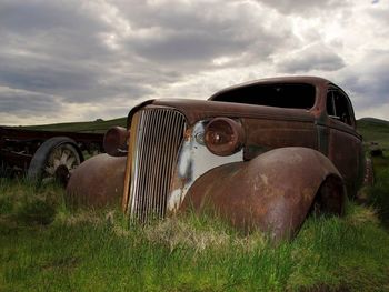 View of grassy field against cloudy sky