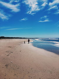 View of calm beach against blue sky