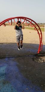 Boy playing at playground against clear sky