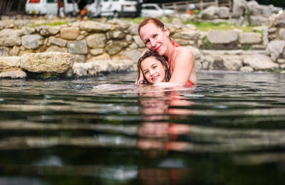 Portrait of happy mother and daughter embracing in lake