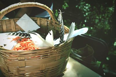 Feathers in wicker basket on table