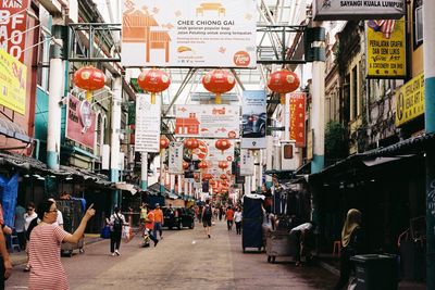 People on street amidst buildings in city