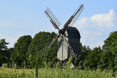 Traditional windmill on field against sky