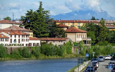 Houses by road in town against sky