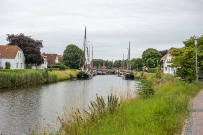 Scenic view of river by buildings against sky