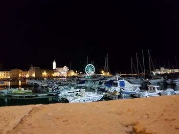 Sailboats moored on sea against clear sky at night