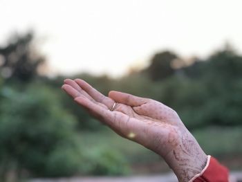 Close-up of hand against sky