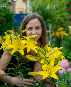 Portrait of young woman amidst yellow flowers