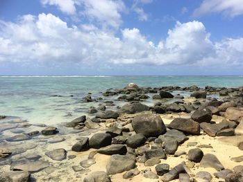 Rocks on beach against sky