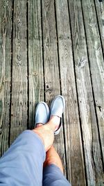 Low section of woman standing on wooden floor