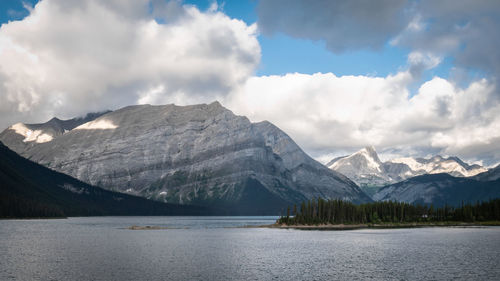 Scenic view of mountains and lake against cloudy sky