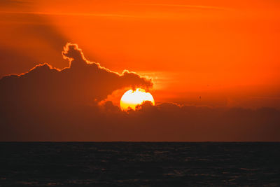 Scenic view of sea against orange sky