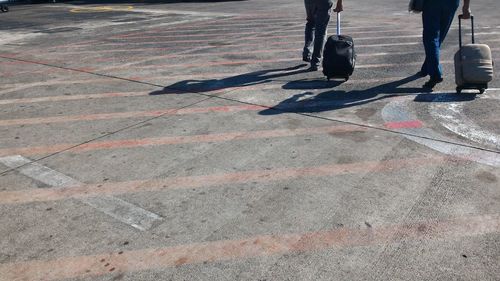 Low section of people walking on airport runway