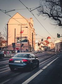 Cars on city street against sky