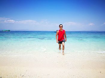 Full length of boy on beach against sky